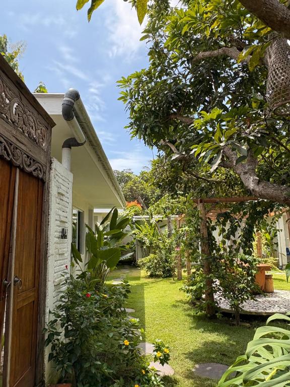 a house with a wooden door and a yard at Casa Della by Kahurangi in Sekongkang