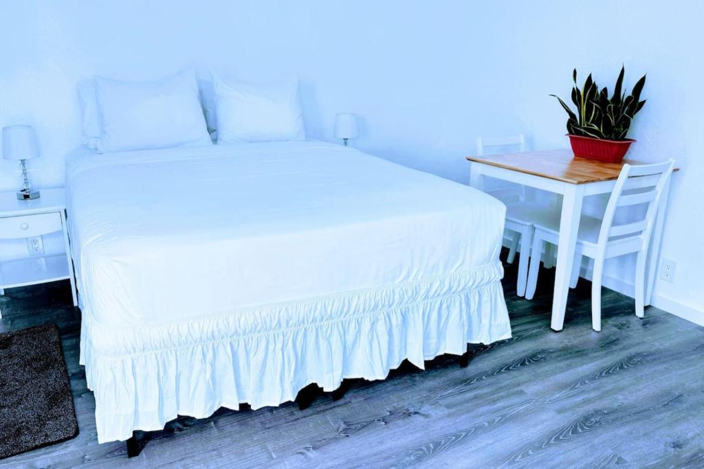 a bedroom with a white bed and a table with a plant at Cozy Twilight Hideaway in Forks