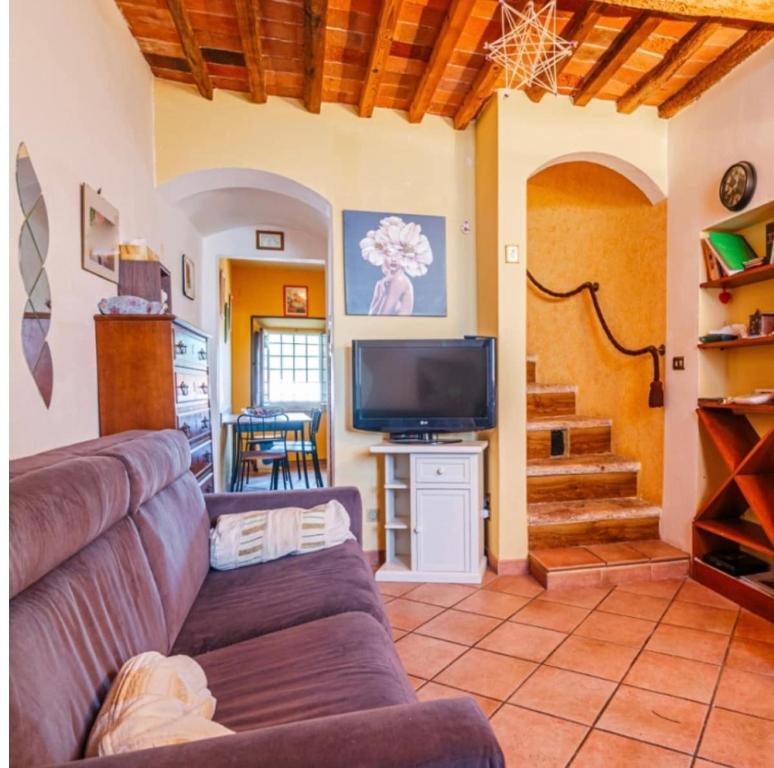 a living room with a couch and a tv at Dimora del Viaggiatore Montecatini Terme in Serravalle Pistoiese