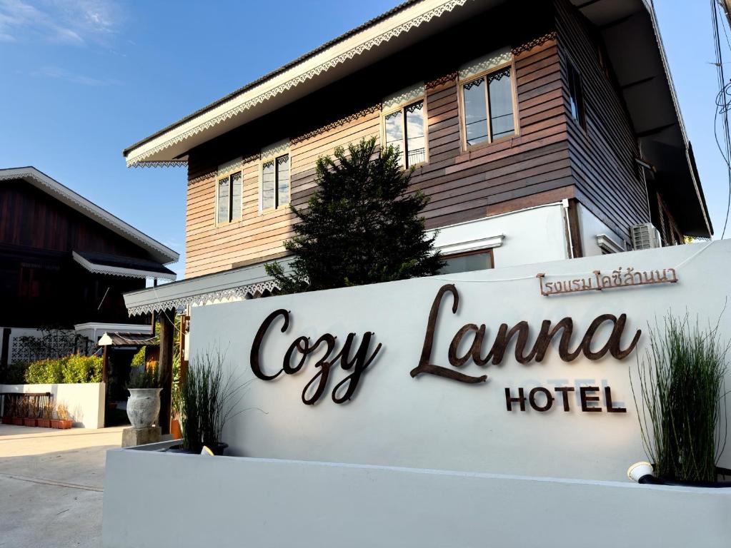a sign for a hotel in front of a building at Cozy Lanna Hotel in Chiang Mai
