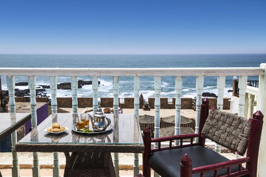 a table and chairs on a balcony overlooking the ocean at Dar Adul in Essaouira