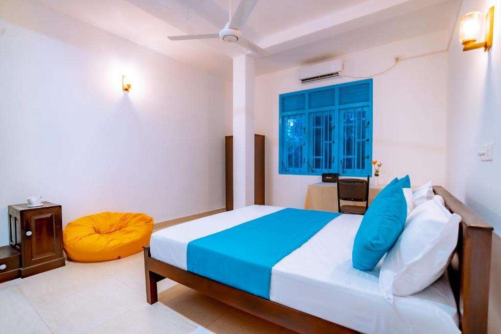 a bedroom with a bed and a blue window at 75 Inn Madiha in Matara