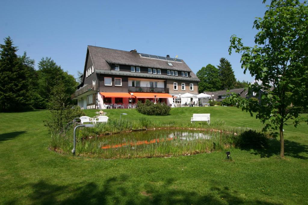 ein großes Haus mit Garten davor in der Unterkunft Hotel Gasthaus Tröster in Schmallenberg