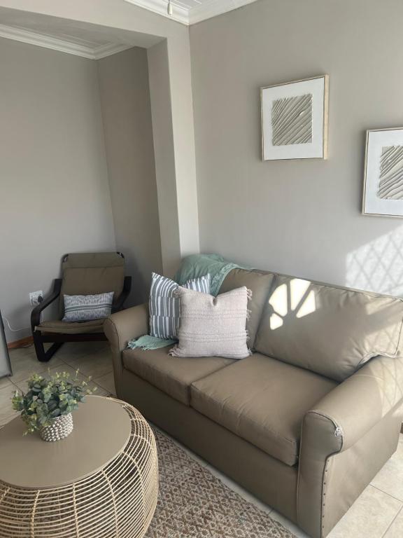 a living room with a couch and a table at The College Suite, Mill Park in Gqeberha
