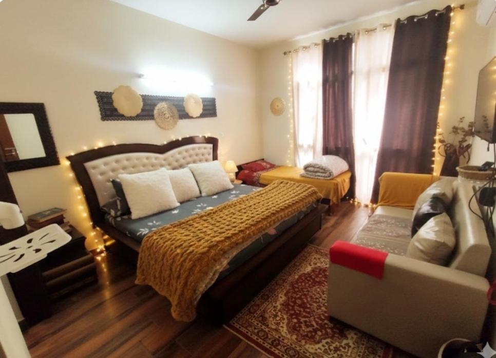 MohaliExclusive Floor on Manali Expressway for Family的带床和沙发的卧室