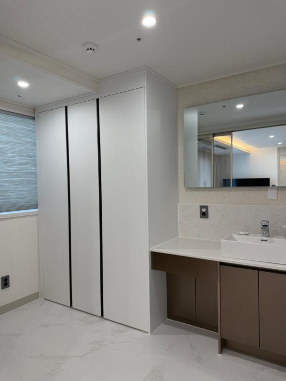 un bagno con lavandino e specchio di Raviens Maison de Hotel a Busan
