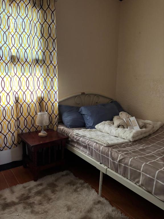 a bedroom with a bed and a table and a window at Maru Vibe Guest house at Panicsican San Juan Elyu in San Juan