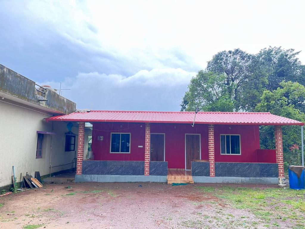 a small red house with a red roof at Malnad cloud homestay Agumbe in Someshwar