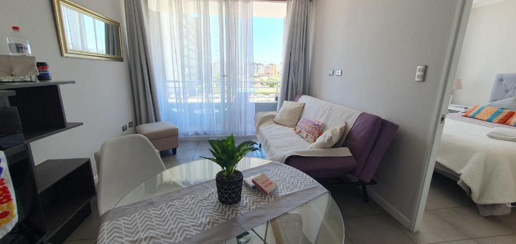 een woonkamer met een bank en een glazen tafel bij I A pasos de la playa y del centro in La Serena