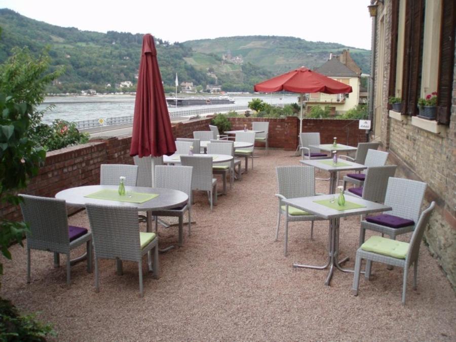 un restaurante con mesas, sillas y sombrilla en Weingut Theodor Nies, en Lorchhausen
