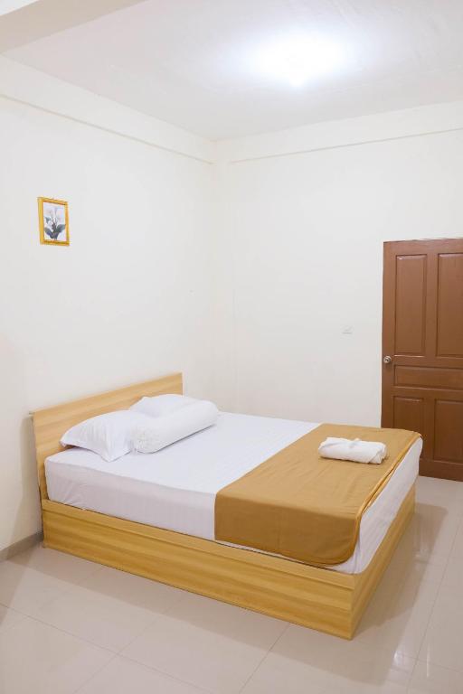 a bedroom with a bed and a wooden cabinet at Elmo Living in Yogyakarta