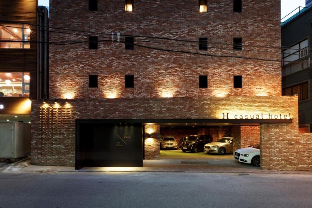 a brick building with cars parked in a garage at Seocho H hotel in Seoul