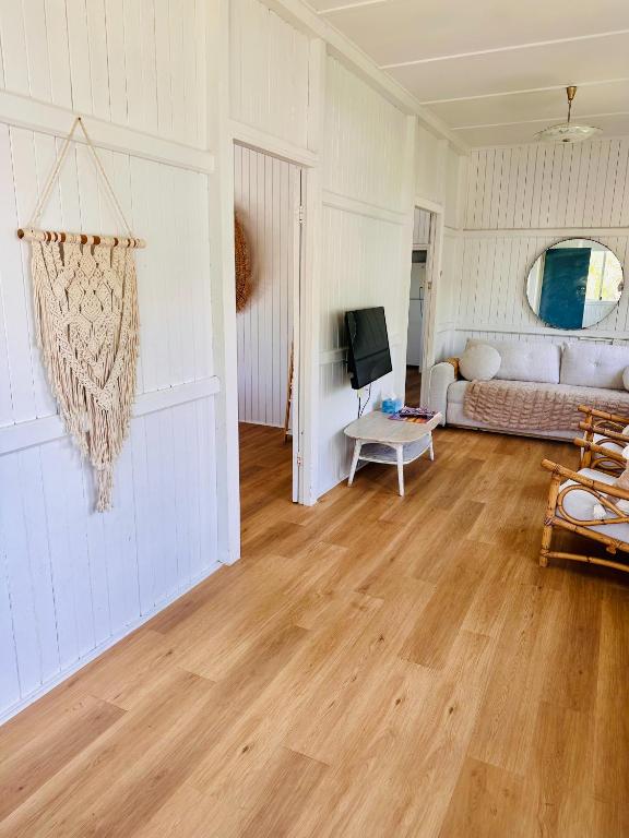 a living room with a couch and wooden floors at Noosa River Gem in Noosaville