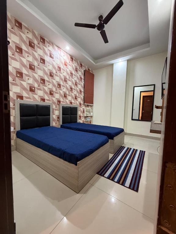 a bedroom with a blue bed and a brick wall at Ganesh Living in Gurgaon