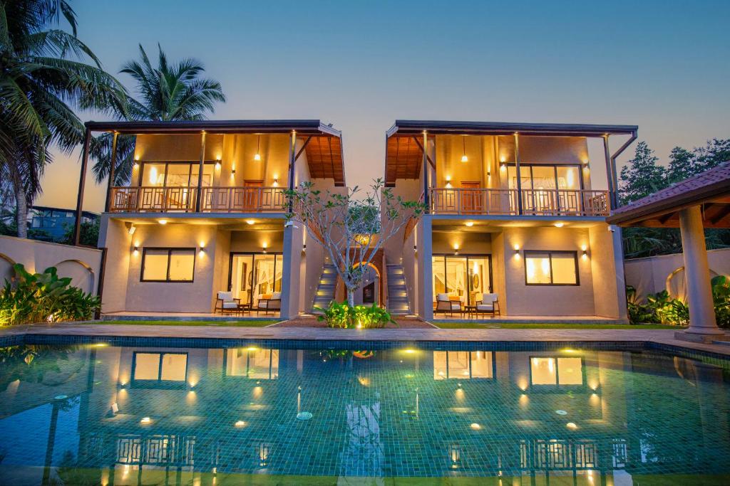 a house with a swimming pool in front of it at La Lassaura in Unawatuna