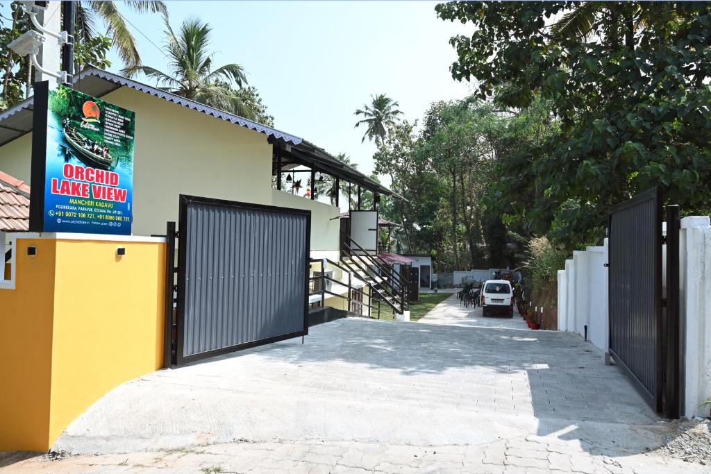 a garage with a gate and a building at Orchid Lake View Resort in Paravūr