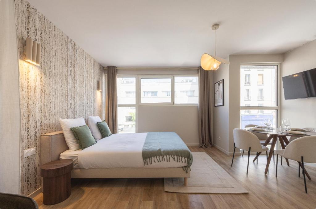a bedroom with a bed and a dining room at Studio moderne et climatisé - proche Paris in Le Pré-Saint-Gervais