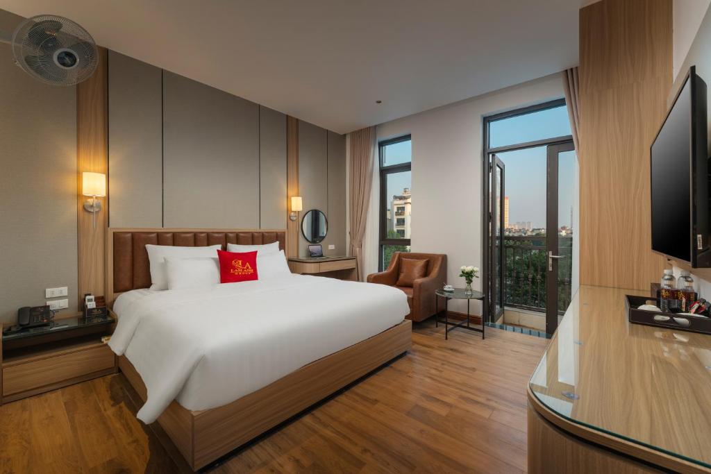 a hotel room with a bed and a television at Lam Anh Hotel 9 Him Lam Vạn Phúc in Hà Ðông