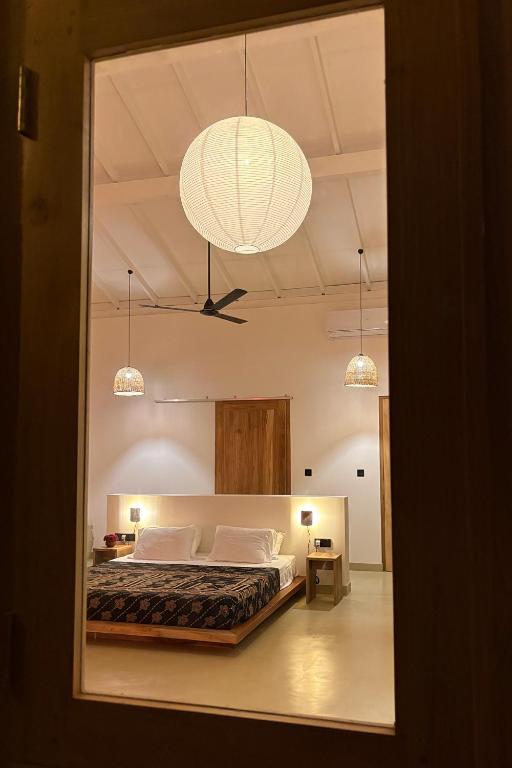 a bedroom with a large bed and a chandelier at Madi House in Matara