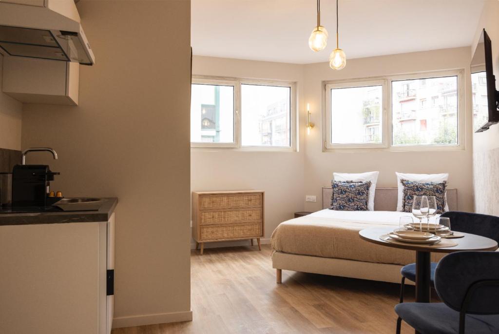 a bedroom with a bed and a table and two windows at Charming and air-conditioned - Close to Paris in Le Pré-Saint-Gervais