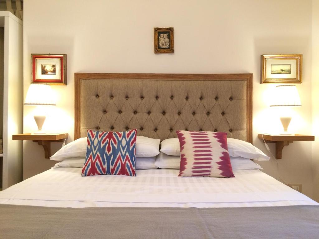 um quarto com uma cama com duas almofadas em Mecenate 69 Suite em Arezzo