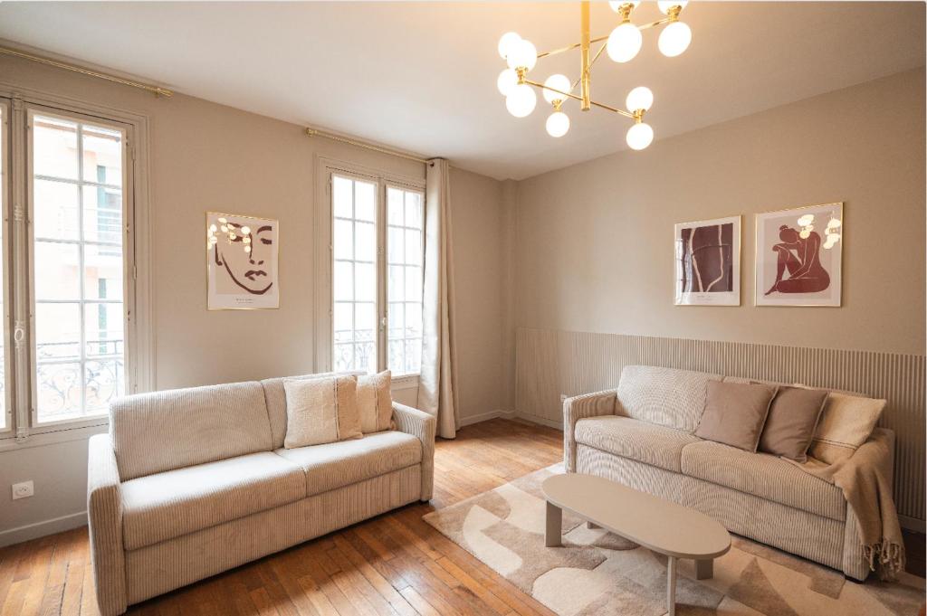 a living room with a couch and a table at Charming and spacious air-conditioned apartment in Le Pré-Saint-Gervais