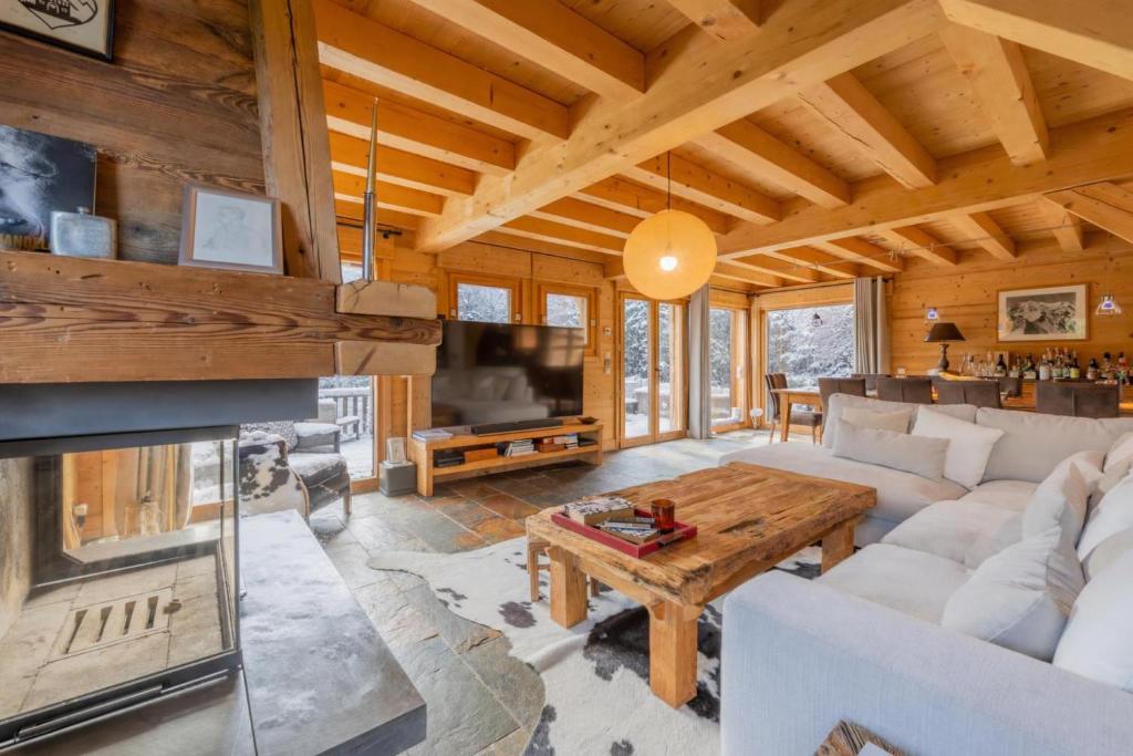 a living room with a white couch and a fireplace at Alpine Luxury Chalet Pool & Jacuzzi in Cordon