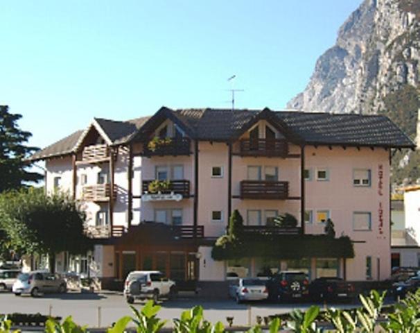 a large building with cars parked in a parking lot at Hotel Ideal in Sarche di Calavino