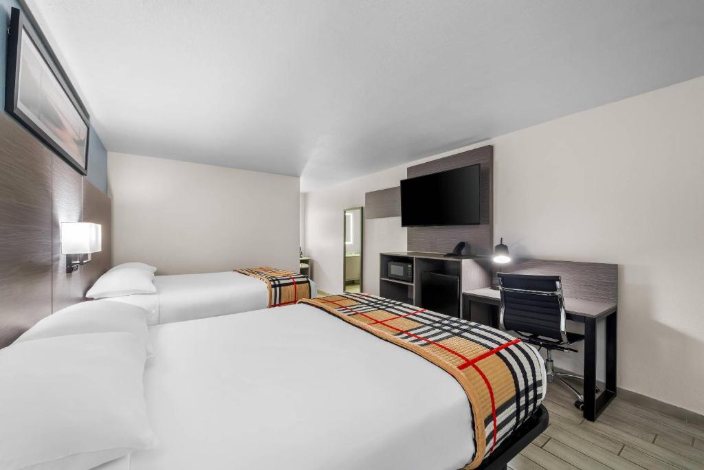 ein Hotelzimmer mit einem großen Bett und einem Schreibtisch in der Unterkunft Rodeway Inn Lake Wales - Winter Haven in Lake Wales