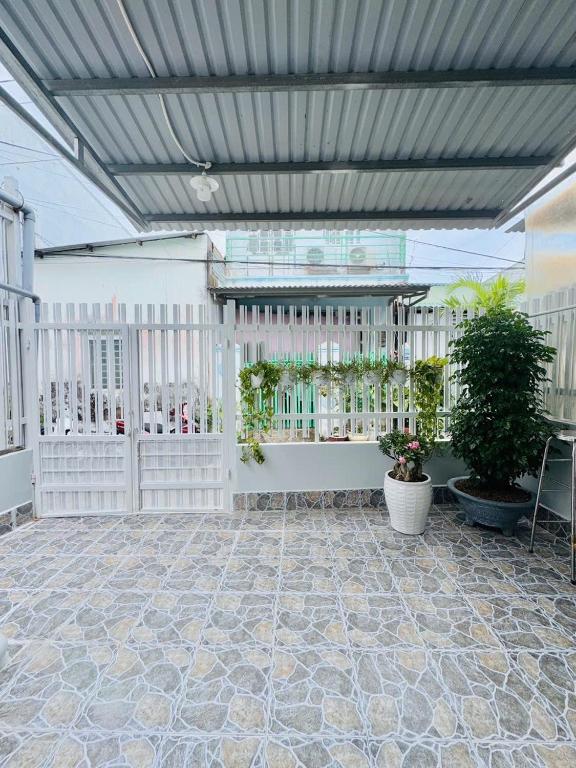 een patio met een wit hek en potplanten bij Homestay Kim Mỹ in Ấp Rạch Mẹo