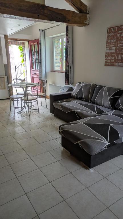 a room with a couch and a table and chairs at Independent studio in nature in Saint-Valérien