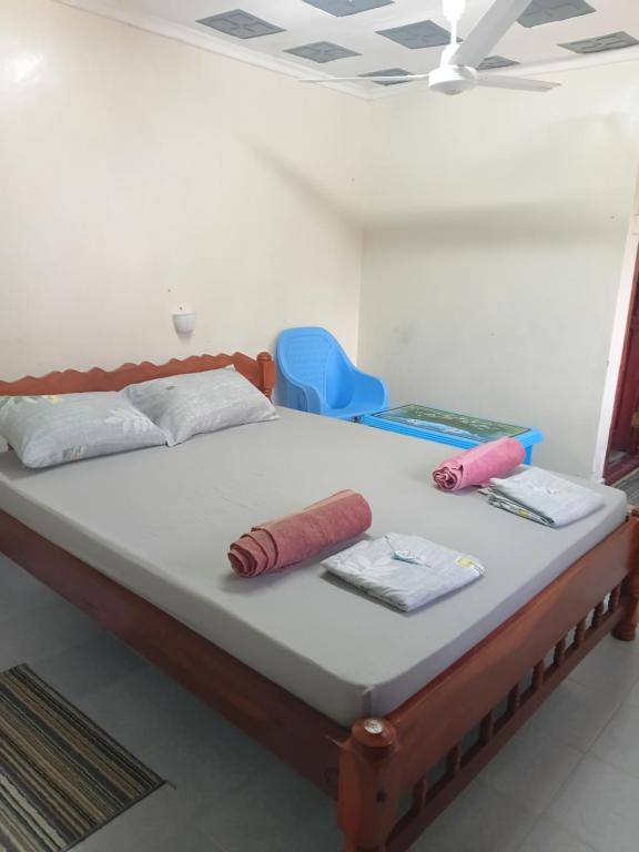 un letto con 2 cuscini e una sedia blu di Amatamata a Malindi