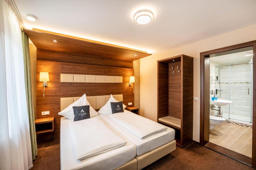 een slaapkamer met een groot bed en een badkamer bij Aspire Castillo Reutlingen, Trademark Collection by Wyndham in Reutlingen