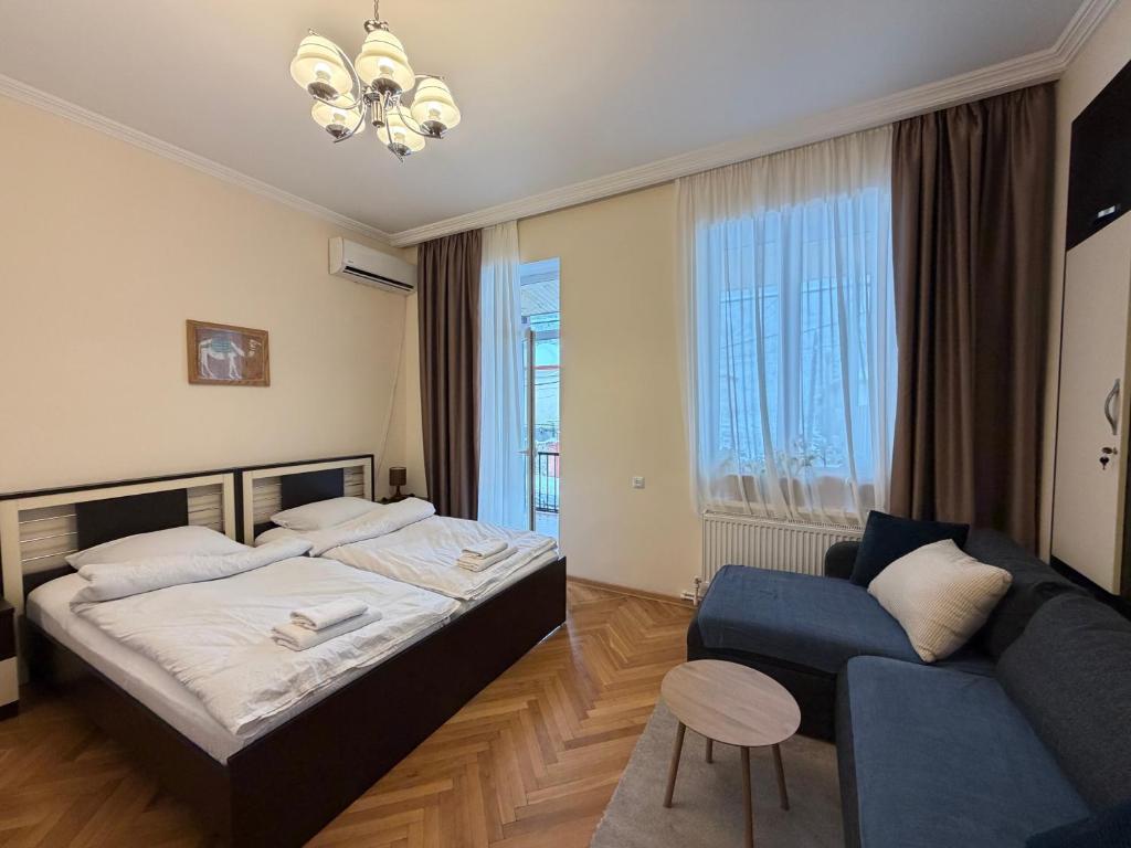 una camera da letto con un letto e un divano di Guest House Gardenia & Wine Cellar a Lagodekhi