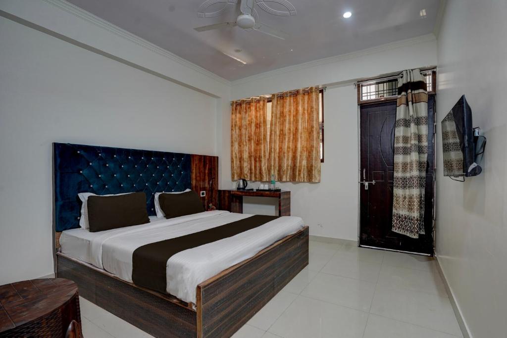 a bedroom with a large bed and a window at Hotel O Swastik Inn in Chinhat