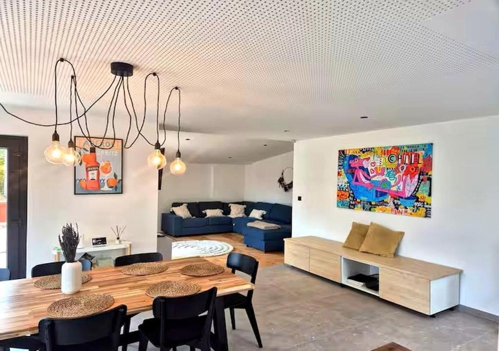 un soggiorno con un tavolo e un divano blu di Chez Simone Liège, bain nordique a Boncelles