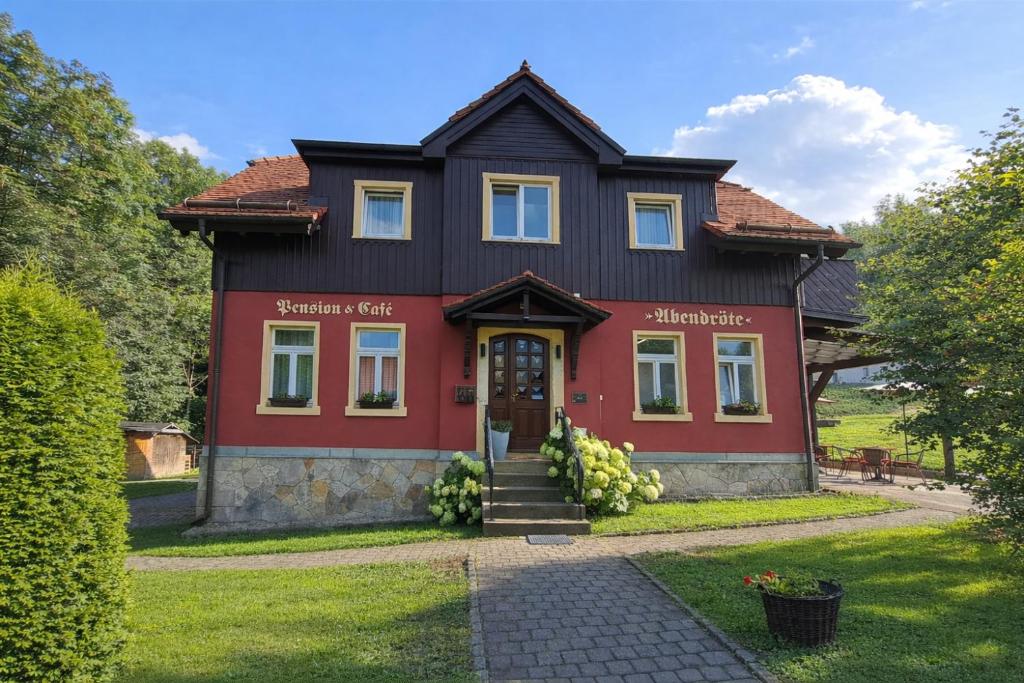 a house with a red and black house at Pension & Café Abendröte in Kurort Oybin