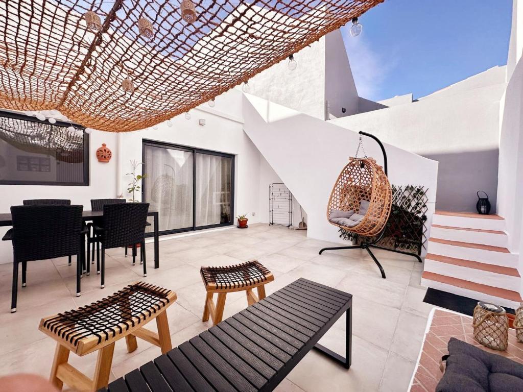 een woonkamer met een tafel, stoelen en een trap bij Algarvia in Parchal