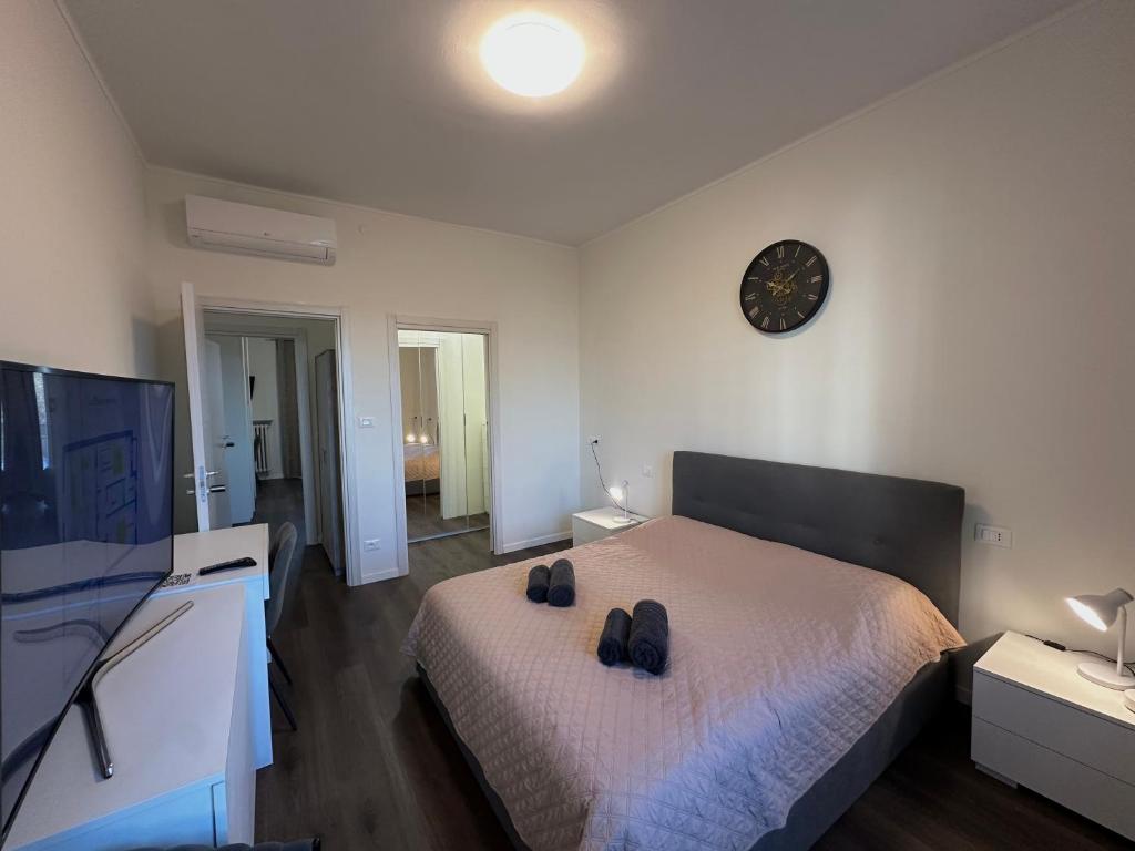 a bedroom with a bed and a clock on the wall at Suite Rossini - 100mq con parcheggio gratuito in Alessandria