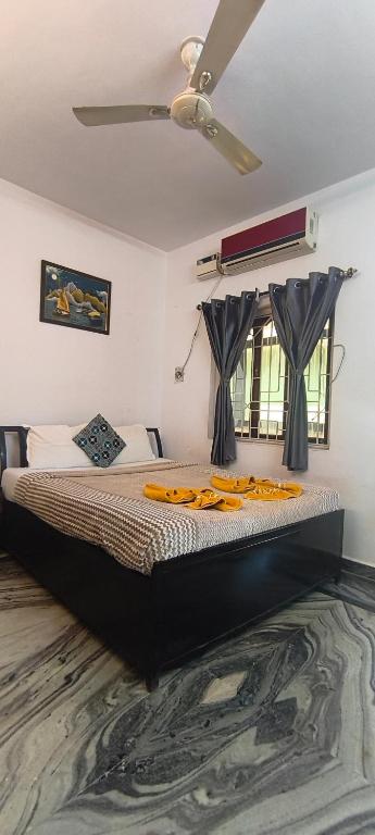 a bedroom with a bed with a ceiling fan at Morni Home's morjim in Morjim