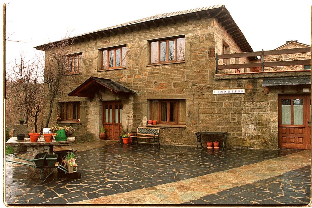 Hotel Rural El Rincón de Trefacio في Trefacio: منزل حجري قديم وامامه موقد