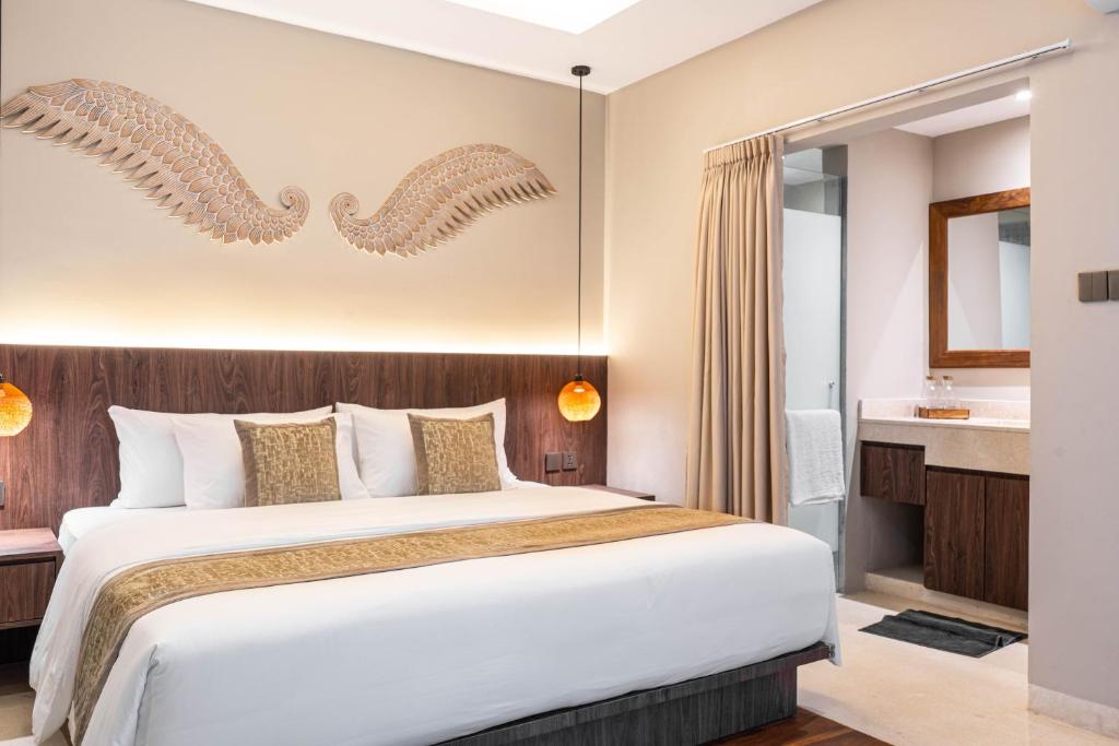 een slaapkamer met een groot bed en een badkamer bij Baliris Home Boutique Legian in Seminyak
