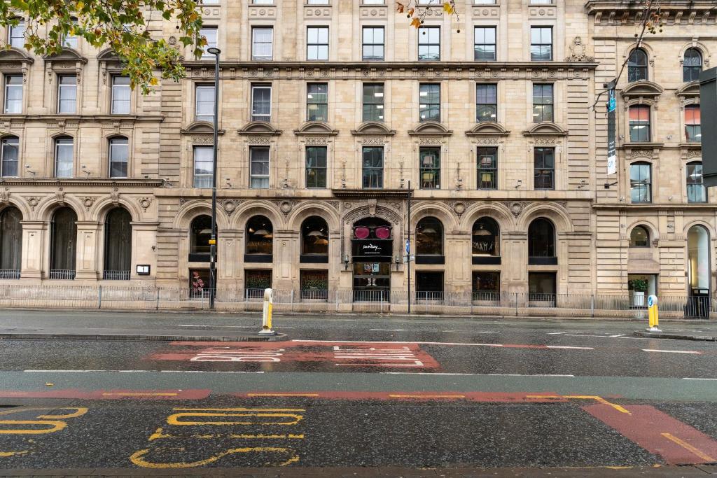 an empty street in front of a large building at Manchester Portland By Sunday in Manchester