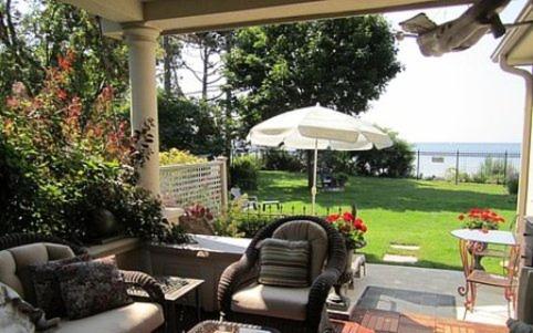 eine Terrasse mit Stühlen, einem Sonnenschirm und einem Tisch in der Unterkunft Willowmere in Cobourg
