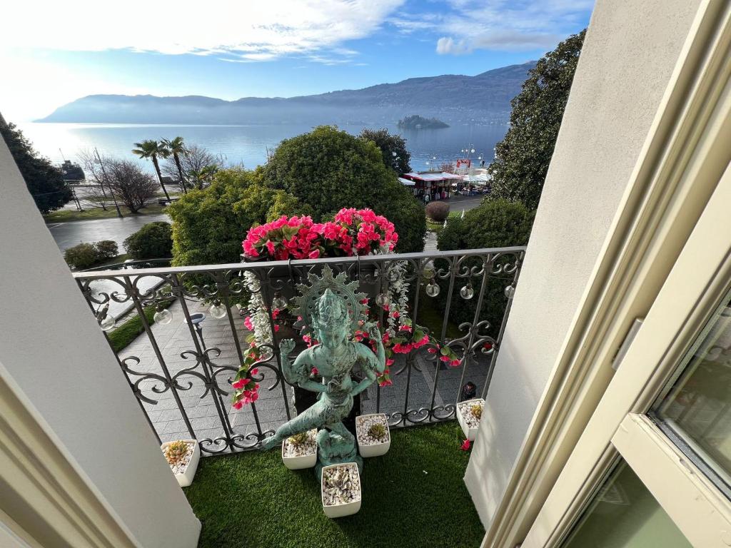 a balcony with pink flowers and a view of the water at Charles in Verbania
