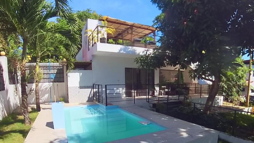 een huis met een zwembad ervoor bij Designer Villa "Sunset Hills" with Pool in Puerto Princesa City