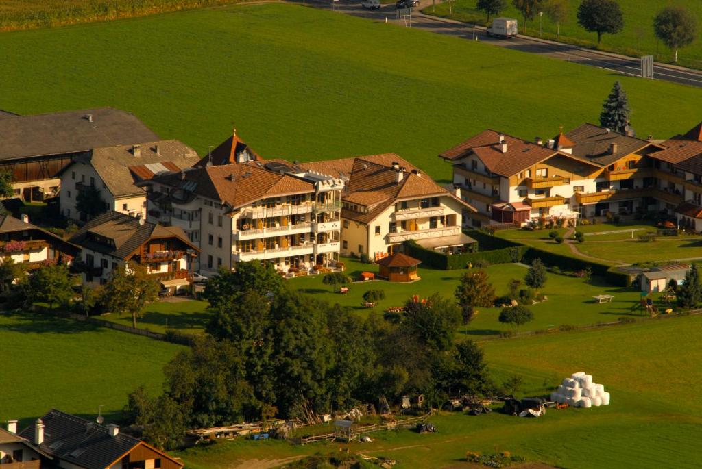 a group of houses in a green field at Hotel Reipertingerhof in Brunico