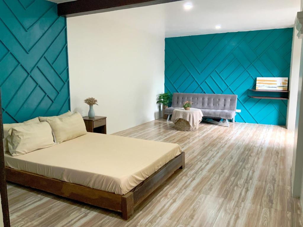 een slaapkamer met een bed en een blauwe muur bij Montego Lakeview House with Taal View in Ulot