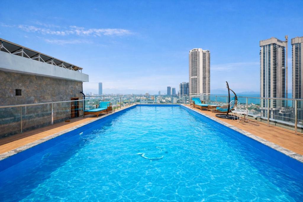 a swimming pool on top of a building with a city skyline at Prague Da Nang Beach Hotel in Danang
