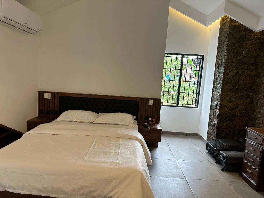 een slaapkamer met een groot bed en een raam bij Asramom Home in Kollam